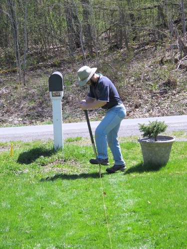 man pushing a spade into the ground.